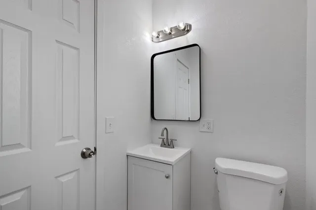 a bathroom with a toilet sink and mirror