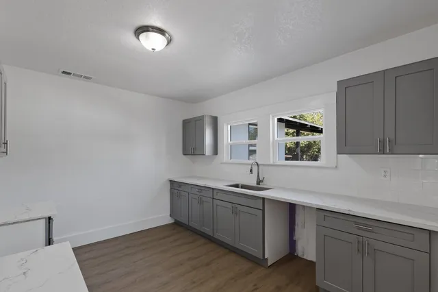 a kitchen with a sink cabinets and wooden floor