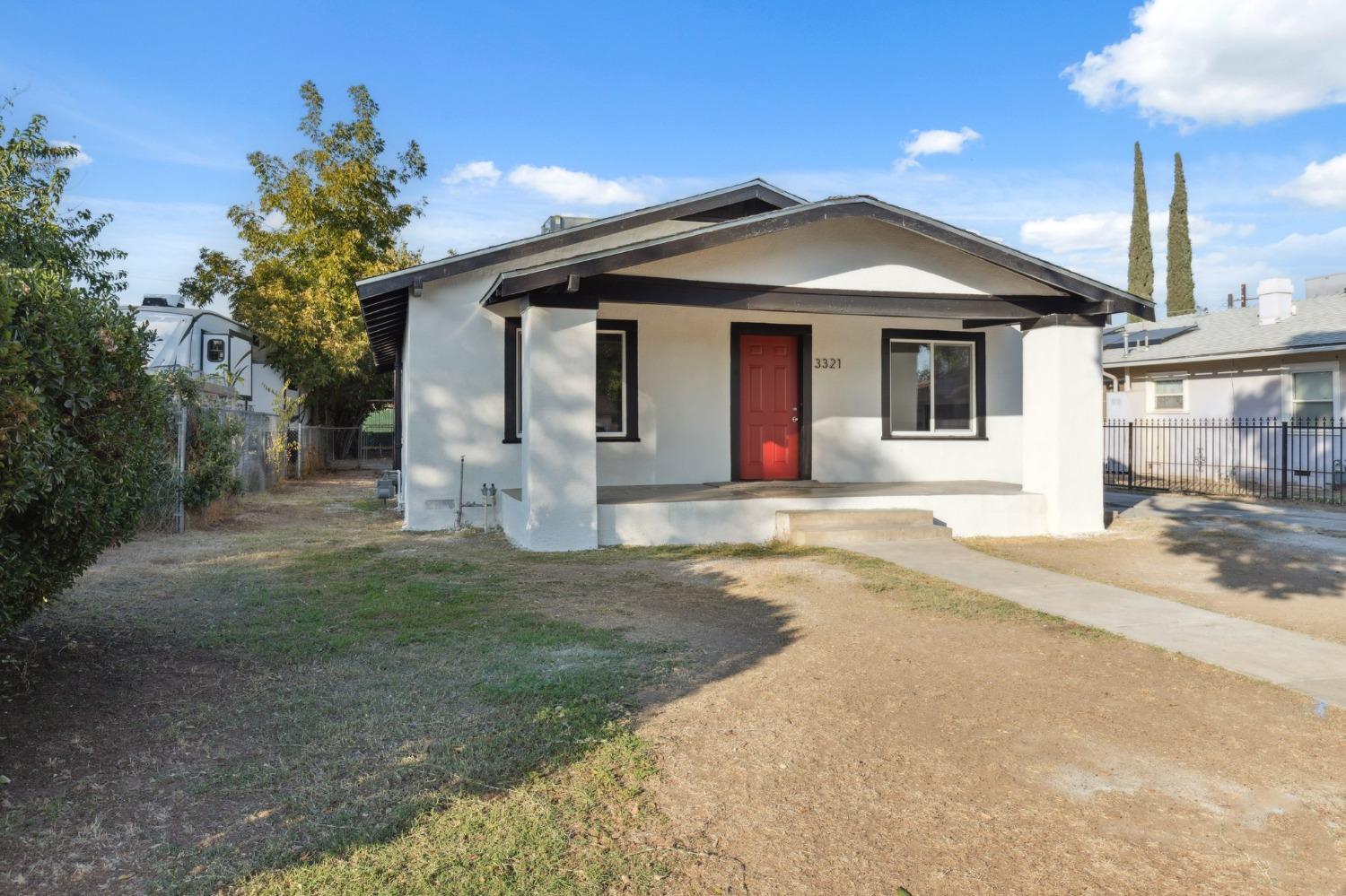 3321 East Montecito Avenue Fresno, CA 93702 - Photo 3 of 22 a front view of a house with a yard and garage