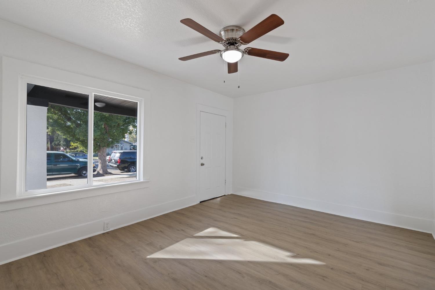 3321 East Montecito Avenue Fresno, CA 93702 - Photo 8 of 22 an empty room with wooden floor and windows
