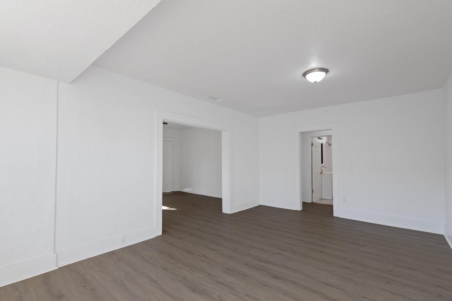 3321 East Montecito Avenue Fresno, CA 93702 - Photo 10 of 22 a view of an empty room with wooden floor