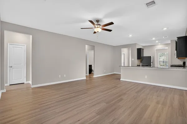 a view of a livingroom with wooden floor and a ceiling fan