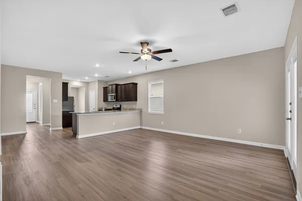 a view of kitchen with cabinets appliances and wooden floor