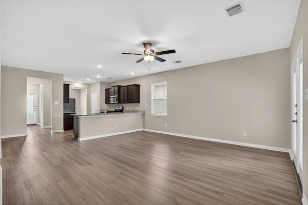 a view of kitchen with cabinets appliances and wooden floor
