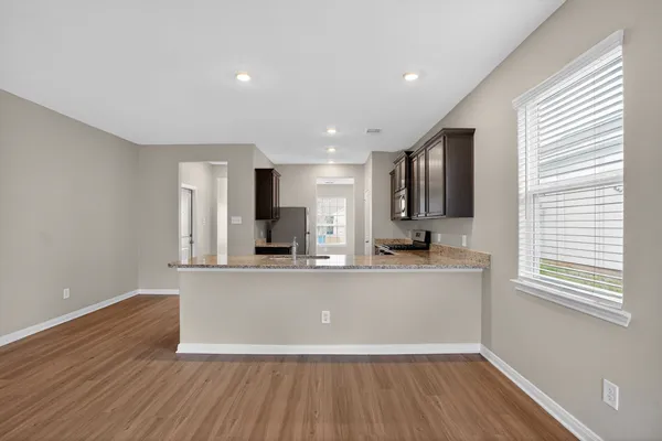 a view of kitchen with stainless steel appliances wooden floor window and refrigerator