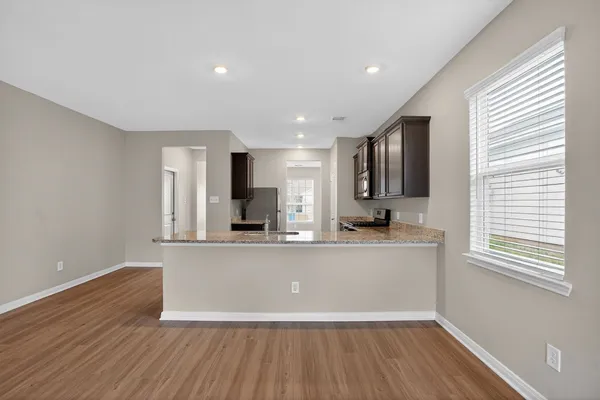 a view of kitchen with stainless steel appliances wooden floor window and refrigerator