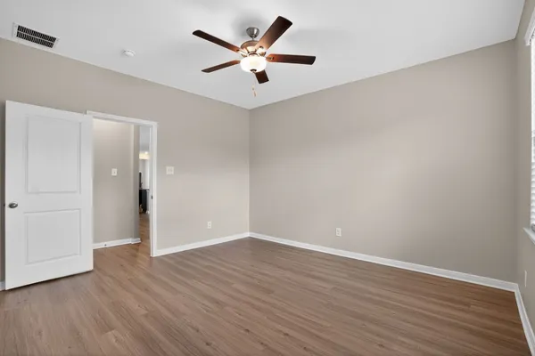 a view of a big room with wooden floor and a ceiling fan