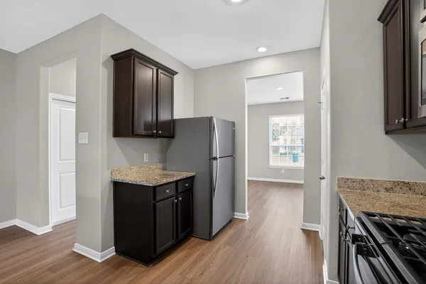a kitchen with stainless steel appliances granite countertop a stove a refrigerator and a microwave