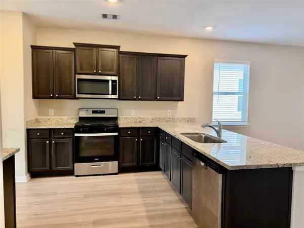 a kitchen with a sink stove top oven and microwave