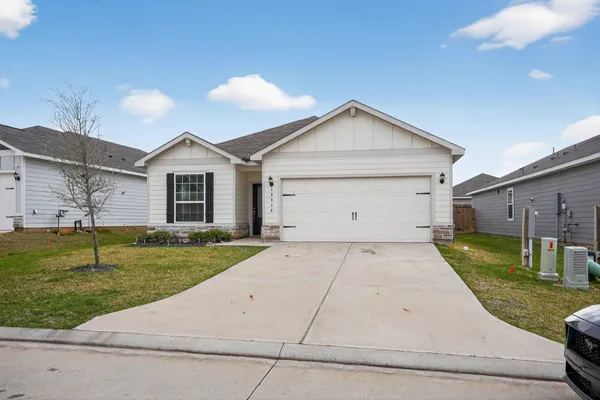 a view of a white house with a yard and garage