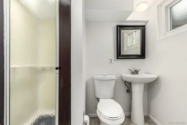 a bathroom with a toilet a sink and mirror