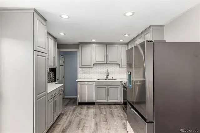a kitchen with stainless steel appliances granite countertop a refrigerator and a sink