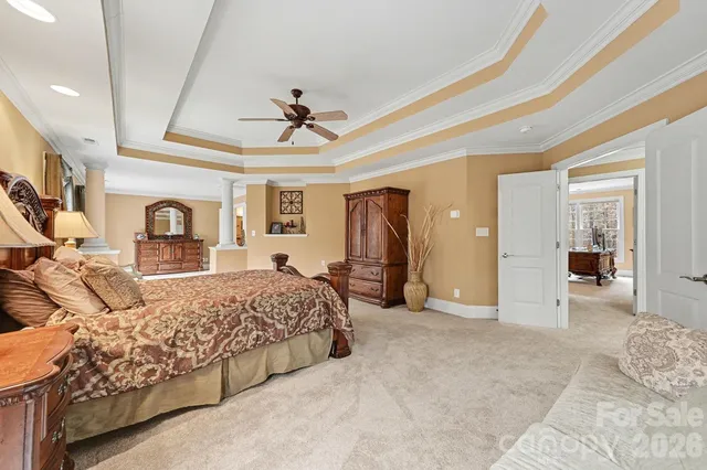 a spacious bedroom with a large bed and a chandelier