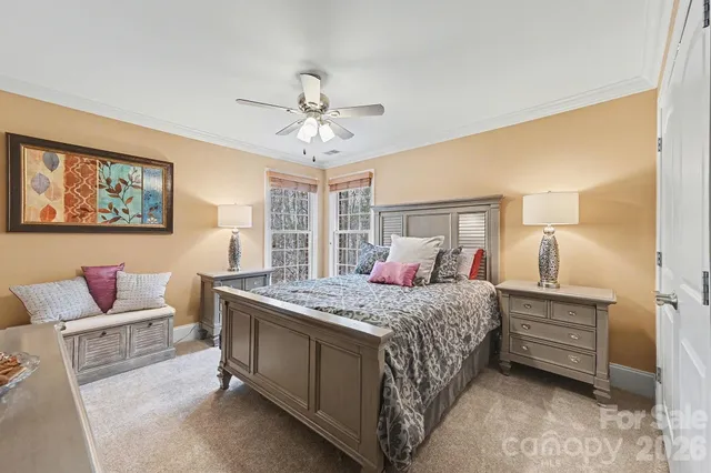 a bedroom with a bed a chandelier and a dresser
