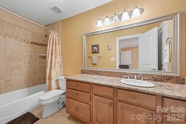 a bathroom with a granite countertop sink toilet a large mirror a bathtub and shower