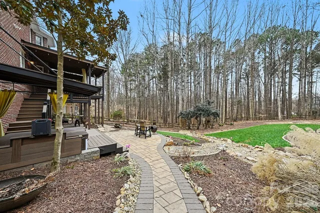 a view of backyard with table and chairs and wooden fence