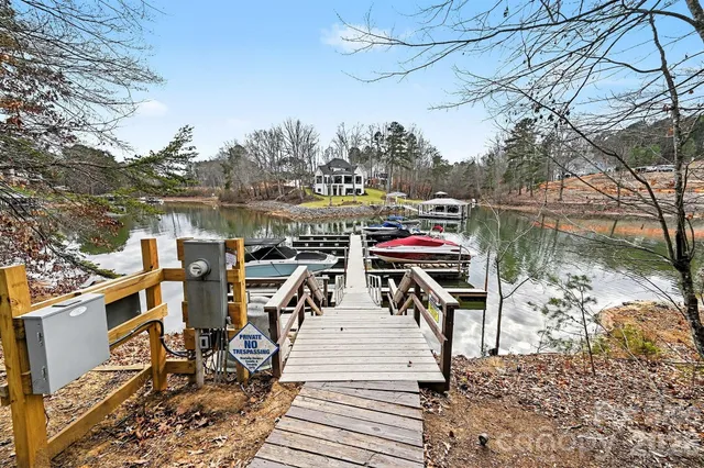 a view of a lake with tables and chairs under an umbrella
