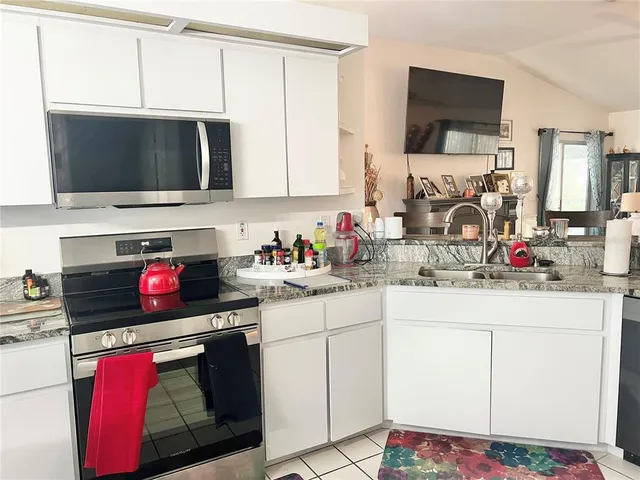 a kitchen with stainless steel appliances a stove microwave and cabinets