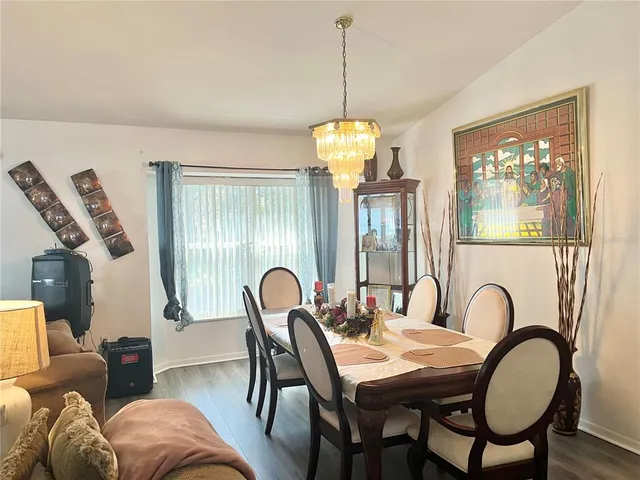 a dining room with furniture a chandelier and window
