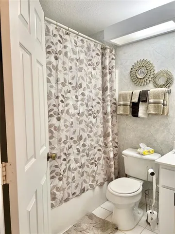 a white toilet sitting next to a shower curtain