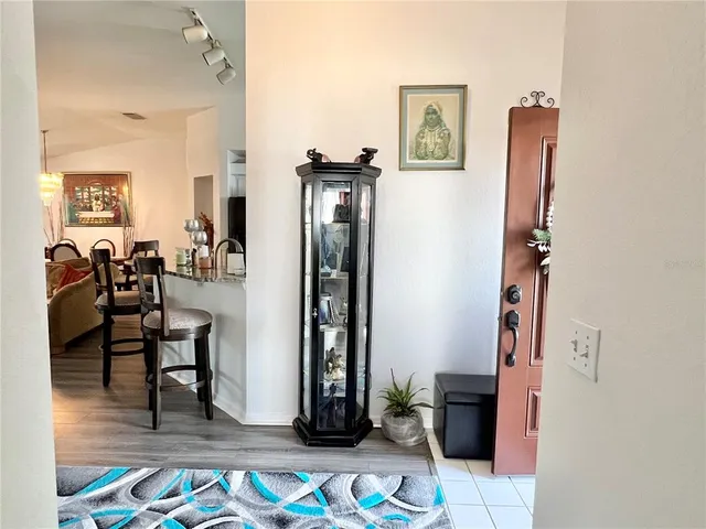 a living room with furniture two large window and a wooden floor