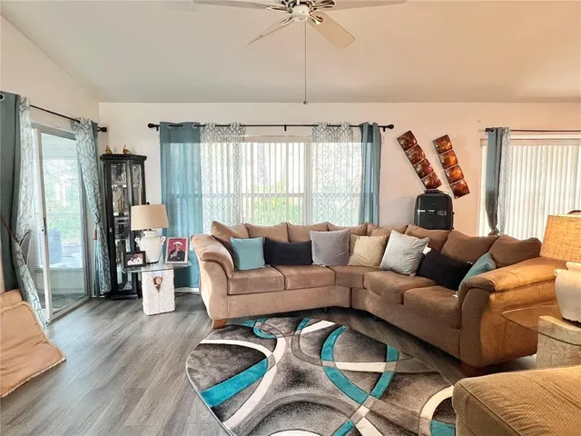 a living room with furniture fireplace and large windows