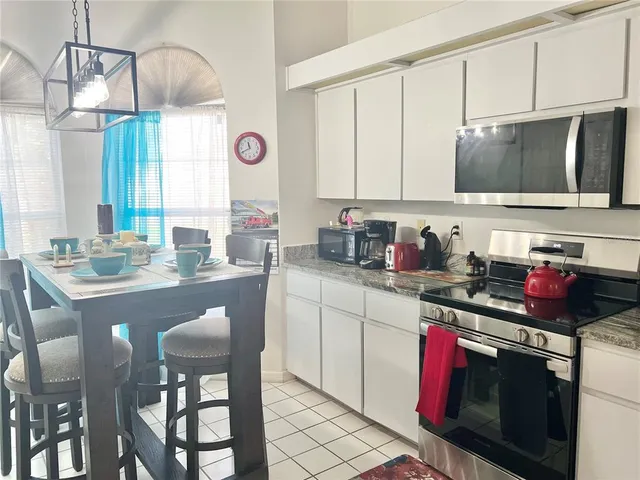 a kitchen with stainless steel appliances granite countertop a sink stove and cabinets