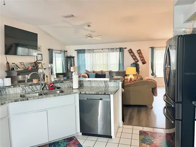 a kitchen with stainless steel appliances granite countertop a sink a stove and a refrigerator