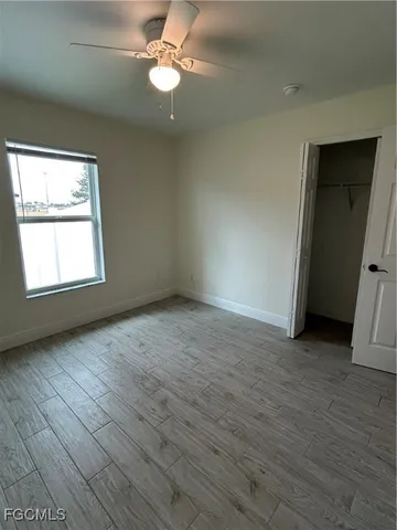 an empty room with wooden floor and window