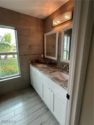 a bathroom with a granite countertop sink and a mirror