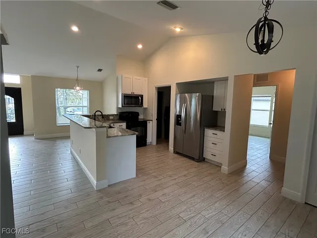 a kitchen with stainless steel appliances a refrigerator and a stove top oven