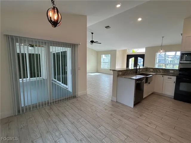 a view of a kitchen with a sink wooden floor and a large window