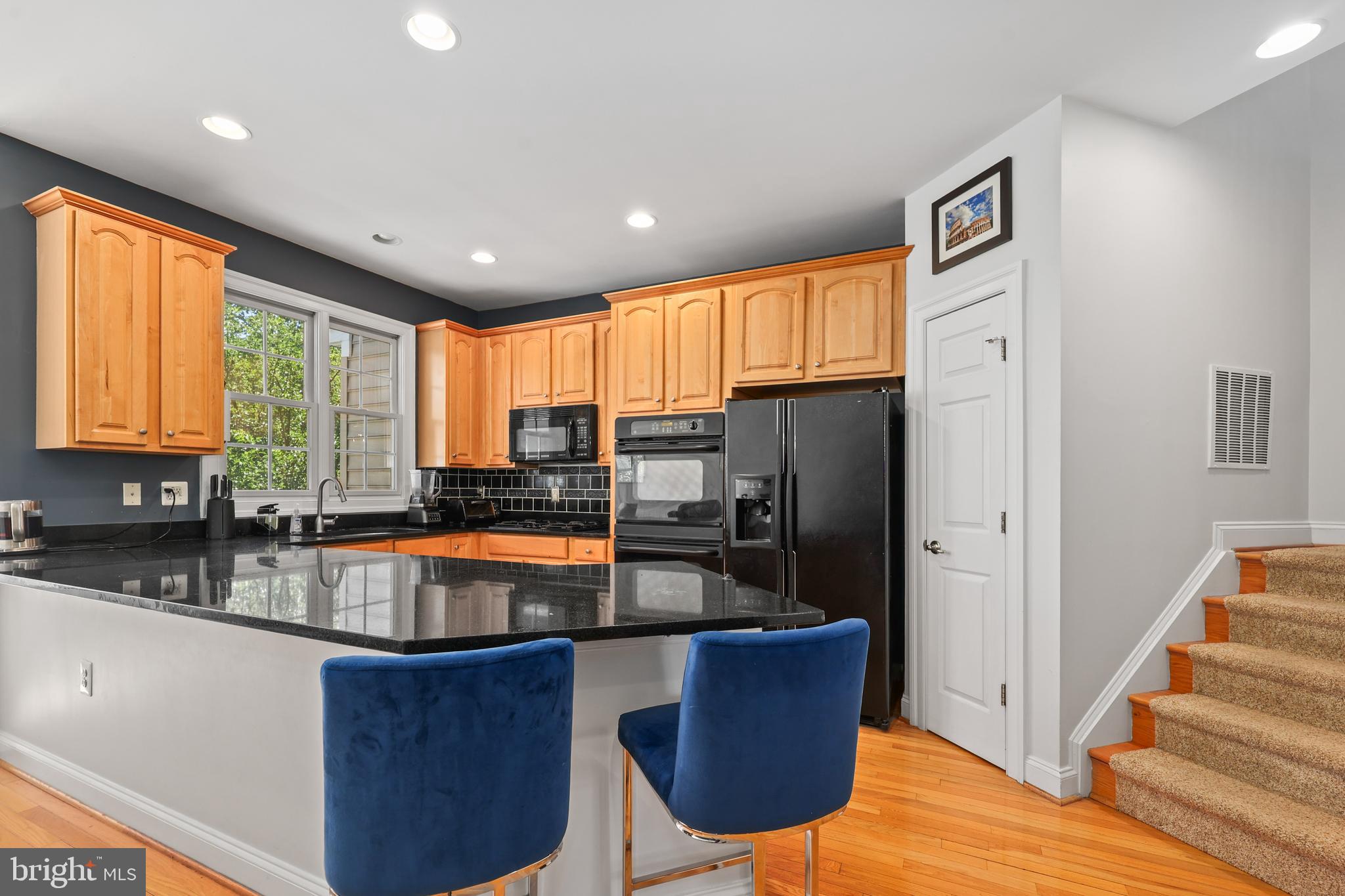 6806 Witton Circle Gainesville, VA 20155 - Photo 13 of 47 a kitchen with stainless steel appliances granite countertop a refrigerator a sink dishwasher a stove and a dining table with wooden cabinet