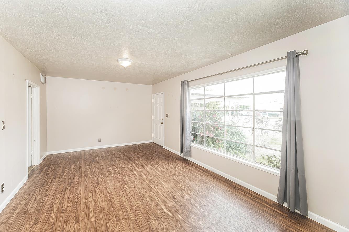 795 West Palm Avenue Reedley, CA 93654 - Photo 4 of 28 a view of an empty room with wooden floor and a window