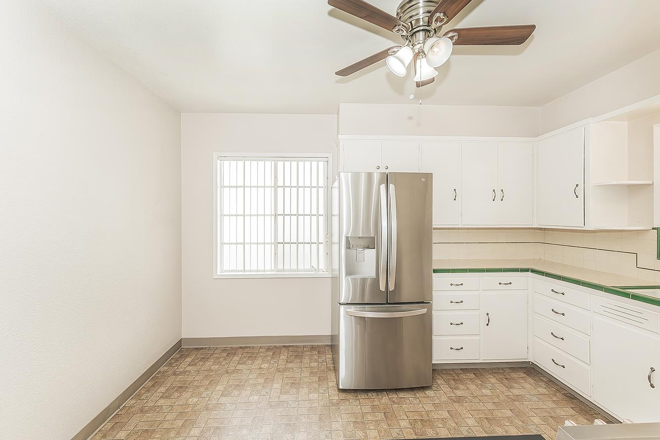 795 West Palm Avenue Reedley, CA 93654 - Photo 5 of 28 a kitchen with a refrigerator a sink cabinets and wooden floor