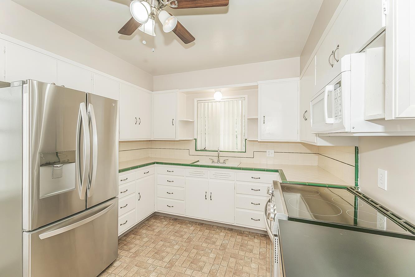 795 West Palm Avenue Reedley, CA 93654 - Photo 8 of 28 a kitchen with granite countertop a refrigerator and a sink