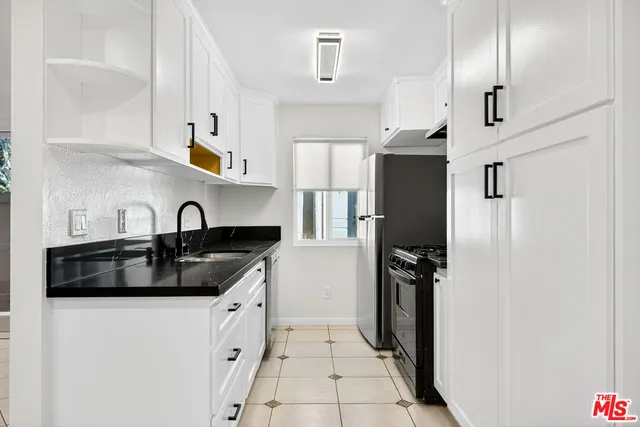 a kitchen with stainless steel appliances a sink stove and refrigerator