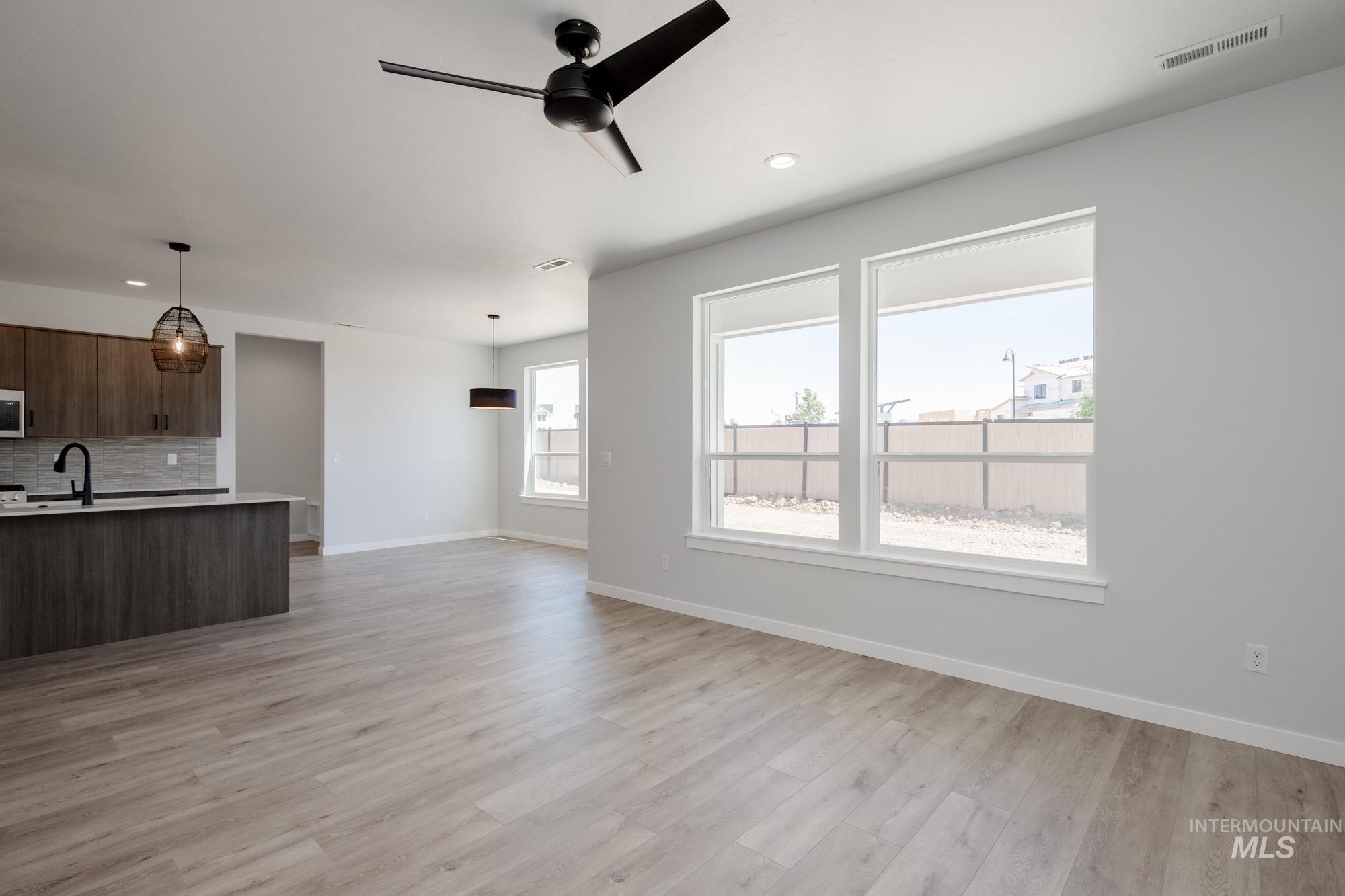 6596 South Banded Eagle Way Boise, ID 83709 - Photo 12 of 28 Unfurnished living room featuring light wood-style floors, a ceiling fan, and recessed lighting
