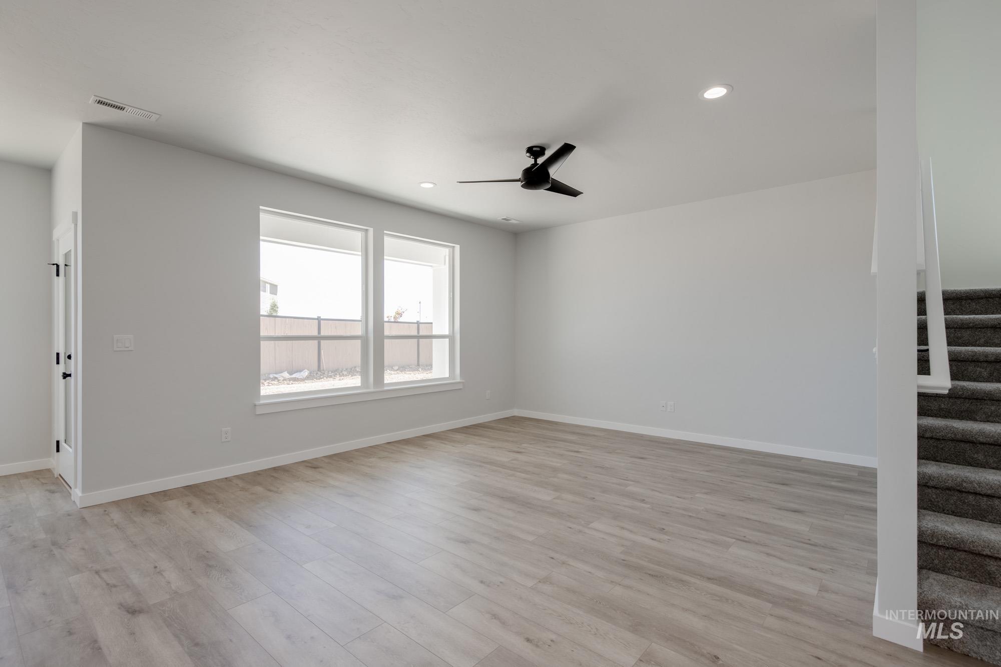 6596 South Banded Eagle Way Boise, ID 83709 - Photo 13 of 28 Unfurnished living room featuring stairway, a ceiling fan, recessed lighting, and light wood finished floors
