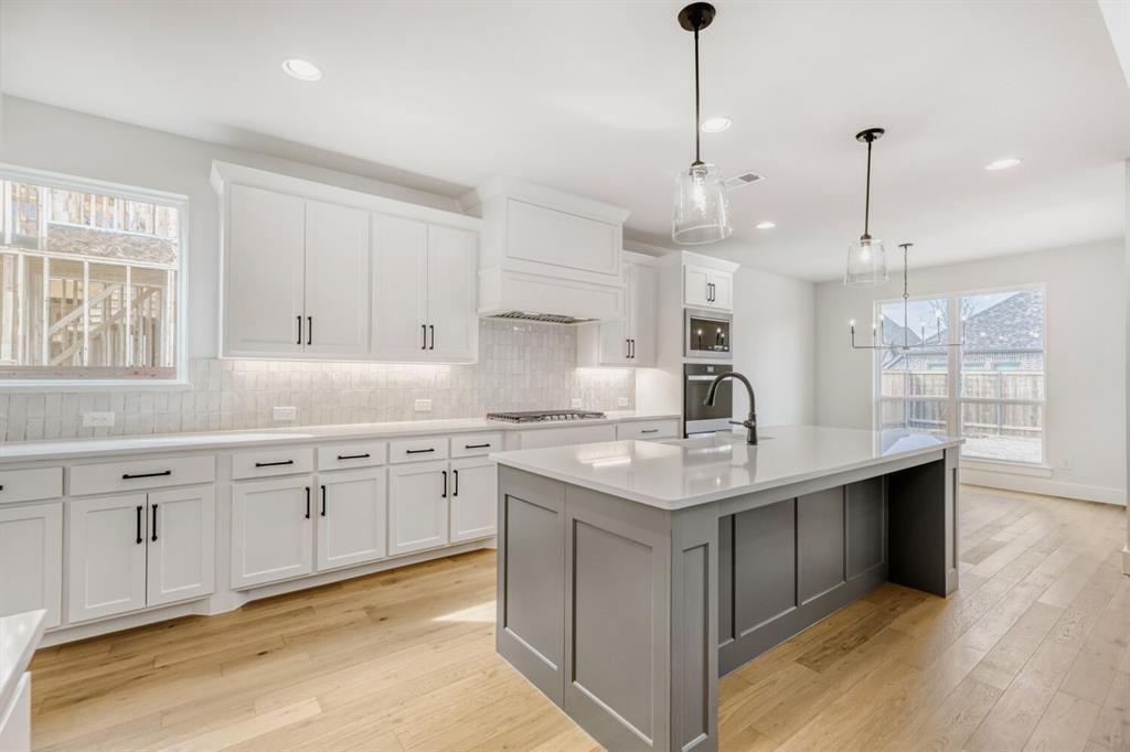 3328 Chinaberry Street Celina, TX 75009 - Photo 7 of 29 a kitchen with granite countertop a sink center island stainless steel appliances and cabinets