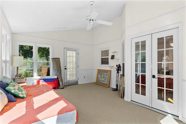 a bedroom with a bed furniture and large windows