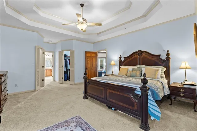 a spacious bedroom with a bed and a chandelier