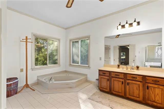 a spacious bathroom with a tub sink and mirror