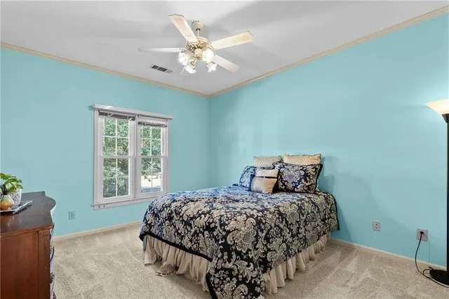 a bedroom with a large bed and a chandelier