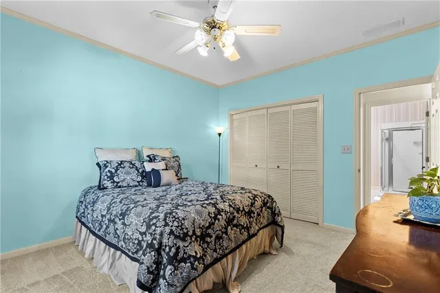a bedroom with a large bed and a chandelier fan