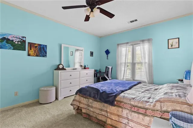 a bedroom with a large bed and a chandelier