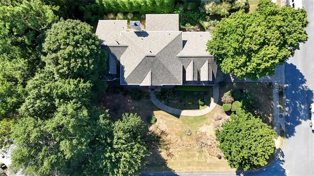 a aerial view of a house with a yard and large trees