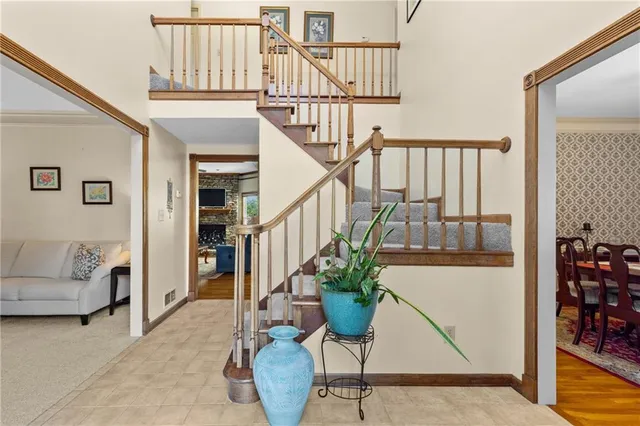 a view of staircase with furniture and lots of frames on wall