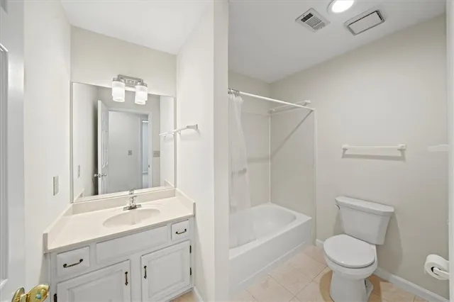 a bathroom with a toilet a sink a mirror a bathtub and vanity