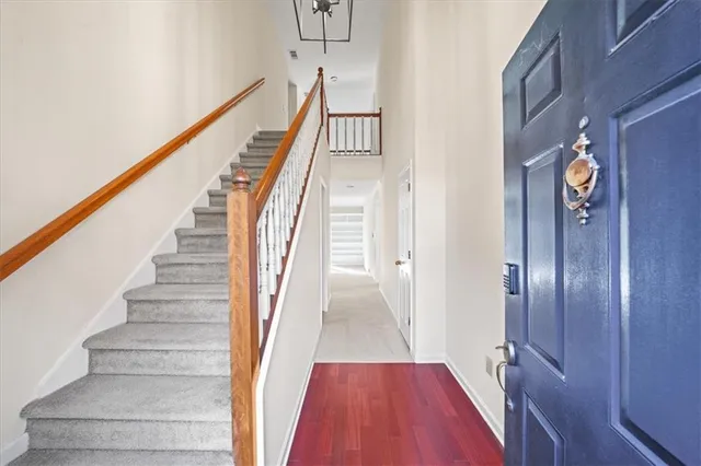 a view of staircase with lots of frames on wall and wooden floor